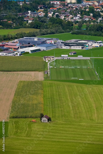 A field with a small house and a tractor in the foreground