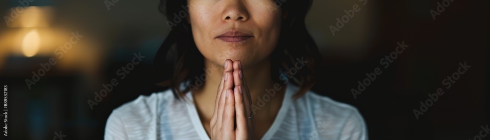 Close-up of a woman meditating with hands in prayer position, creating a serene and peaceful atmosphere.