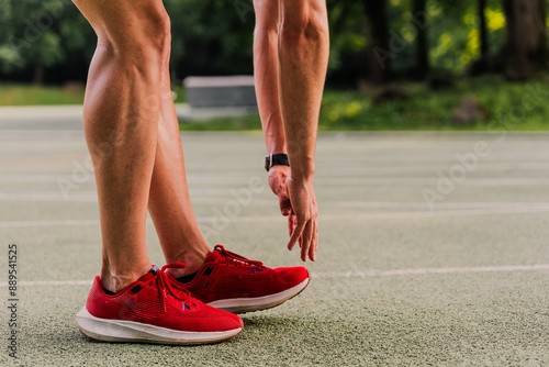 Obraz na płótnie Close-up shot of a runner touching toes to warm up before training