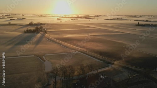 Aerial view of misty sunrise over meadows and farms, Lytsewierrum, Friesland, Netherlands. photo