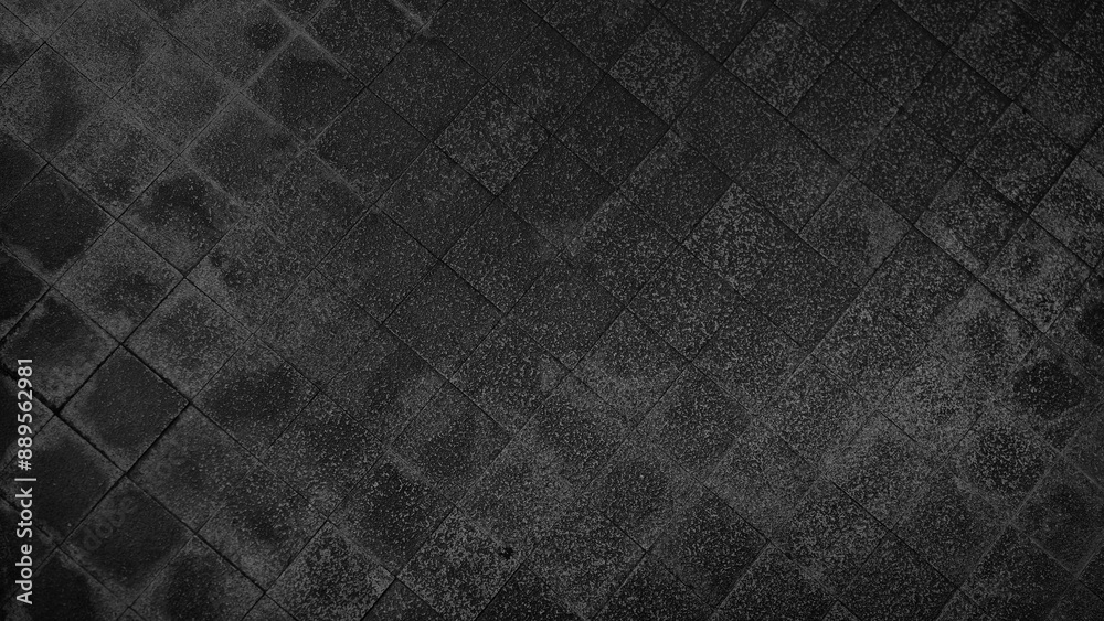 Fototapeta premium rough wet street pathway in grid pattern for design, top view. cobble dark black granite stone, square shape in grid on the outdoor pathway. sidewalk texture made of stone tiles.