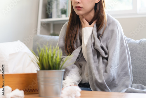 Seasonal sick in winter. Young Asian woman touching her neck feeling hurt in the throat have inflammation and cold. photo