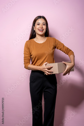 A woman is holding a brown box and smiling