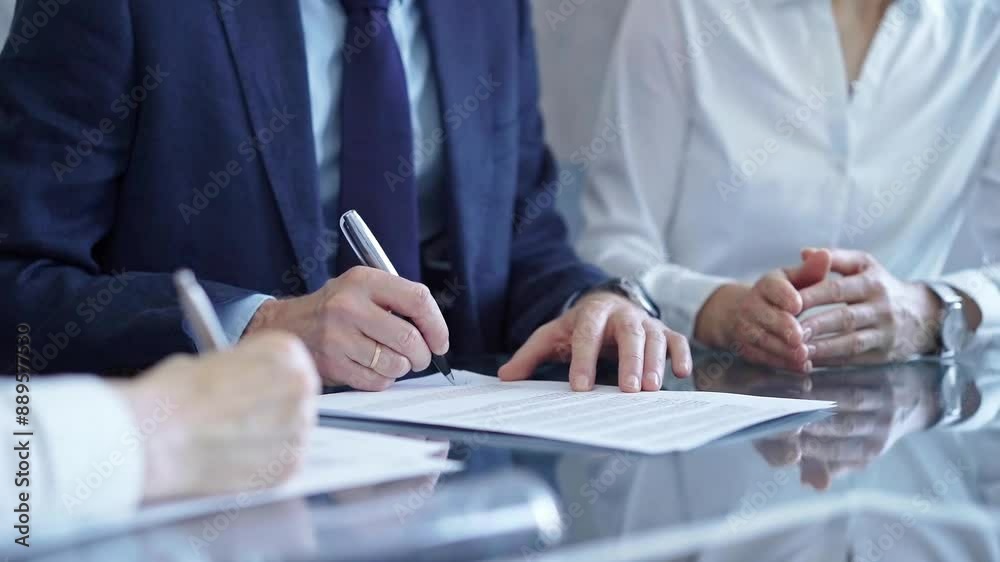 Business people wearing suits signing important documents during a corporate meeting. Win-win concept