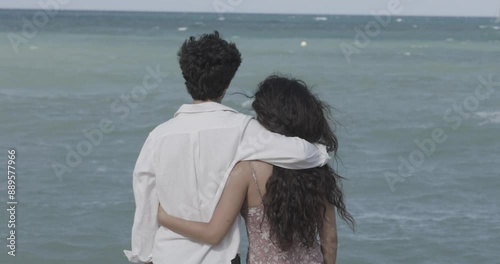 Young couple hugging watching the sea