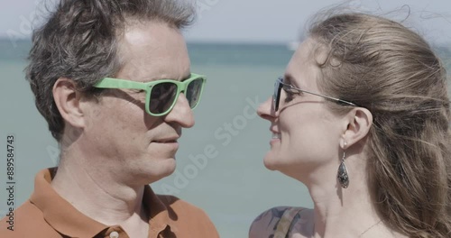Middle-aged couple kissing each other by the sea