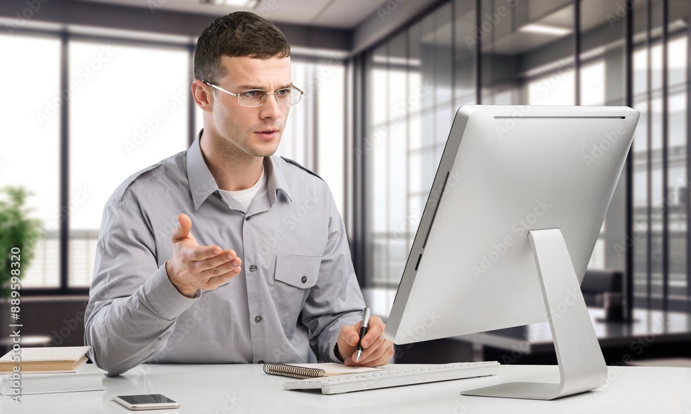 Young happy businessman at work in office Young happy businessman at work in office