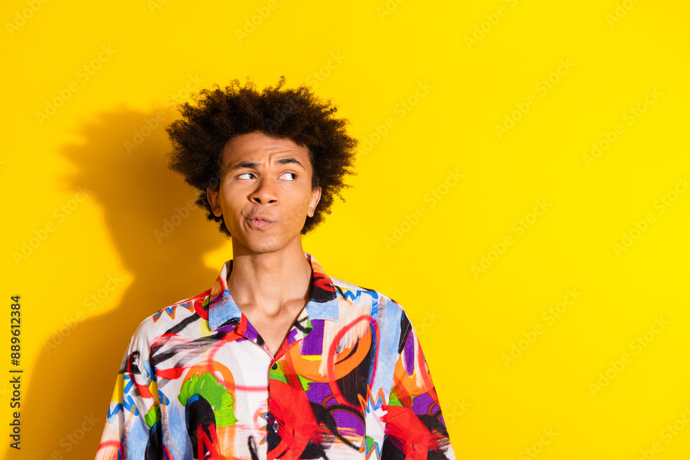 Portrait of nice young man look empty space wear shirt isolated on vivid yellow color background Portrait of nice young man look empty space wear shirt isolated on vivid yellow color background