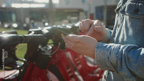 Tourist man take Electric Kick scooter or bike bicycle in sharing parking lot, tourist phone application. New sharing business project started in city, eco transportation