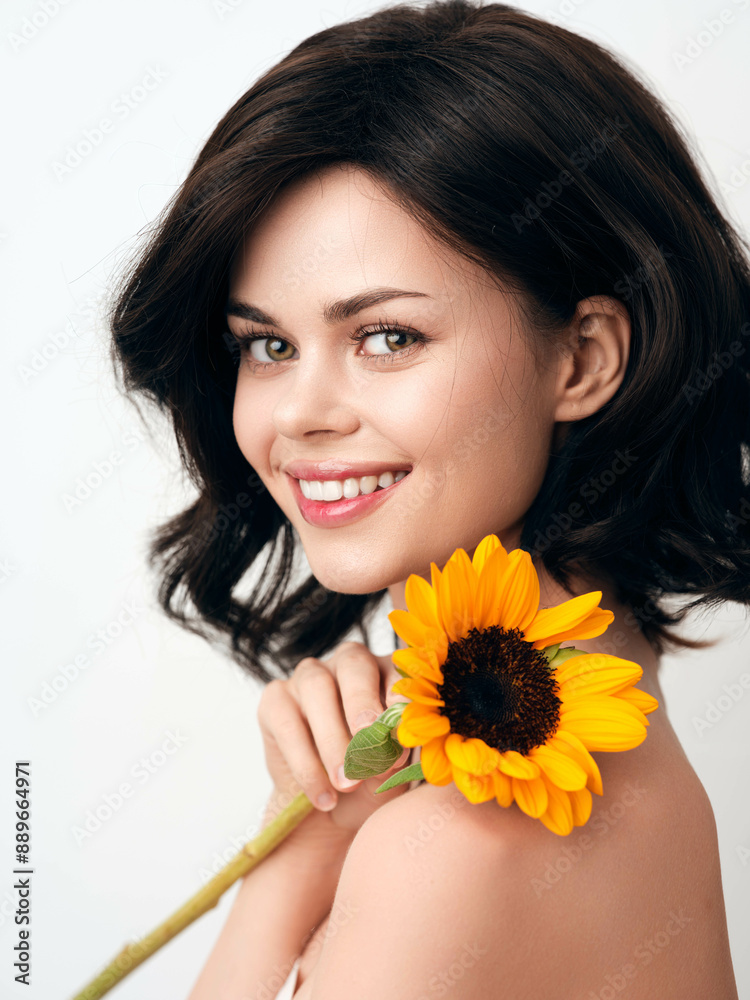 Beautiful young woman holding a sunflower on a white background Beautiful young woman holding a sunflower on a white background
