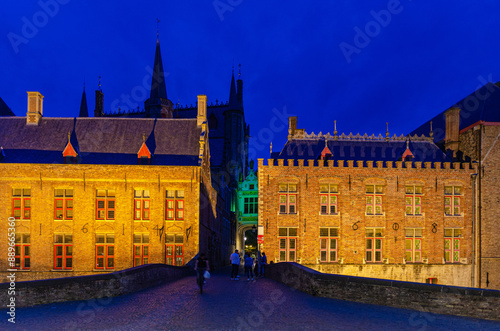 Blinde-Ezelbrug bridge across Groenerei Green Canal in Brugge old town, Stadhuis City Hall and Brugse Vrije Liberty of Bruges building in historical city centre, evening view, Flemish Region, Belgium photo