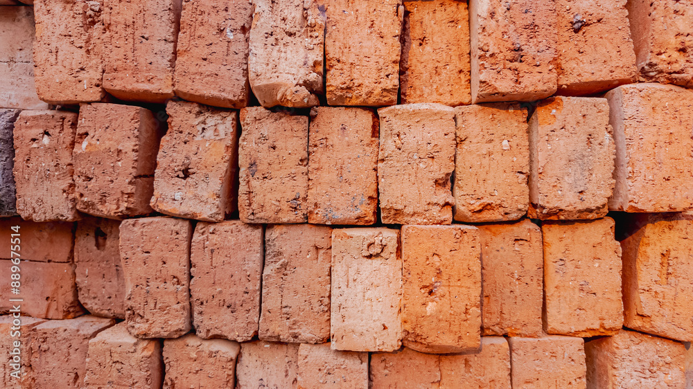 Fototapeta premium A neatly stacked pile of red clay bricks, symbolizing construction and urban development