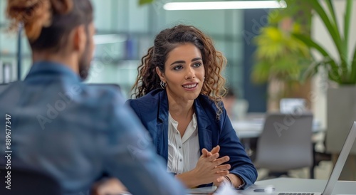 Woman With Curly Hair Discussing Project With Colleague in Modern Office