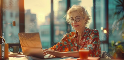 Senior Woman Working On Laptop in Modern Cafe