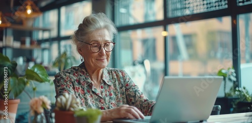 Senior Woman Working On Laptop in Modern Cafe