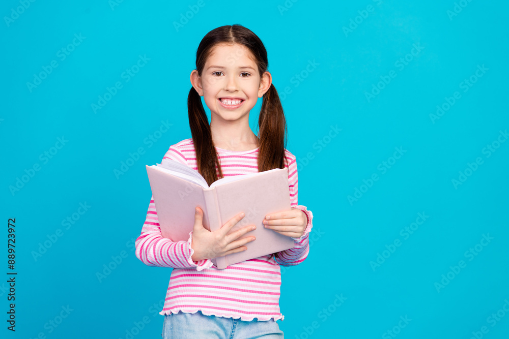Photo of adorable girl with tails dressed striped shirt holding book in hands read interesting story isolated on blue color background