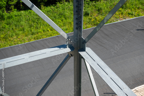 Obraz na płótnie Bolted connections of steel elements of the observation tower. Construction details of galvanized steel against a grey asphalt road surphace w salonie