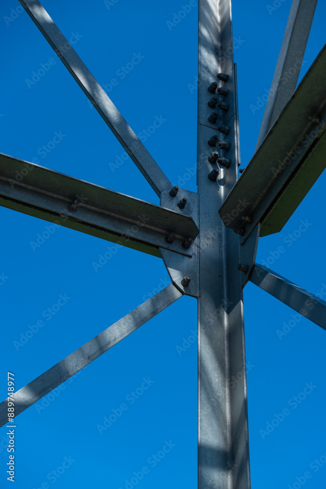 Bolted connections of steel elements of the observation tower. Construction details of galvanized steel against a blue sky background.