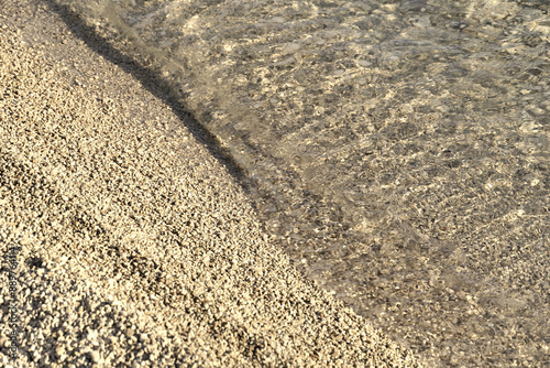 Fototapeta Naklejka Na Ścianę i Meble -  Sea water and small pebbles beach in sepia color tone from above