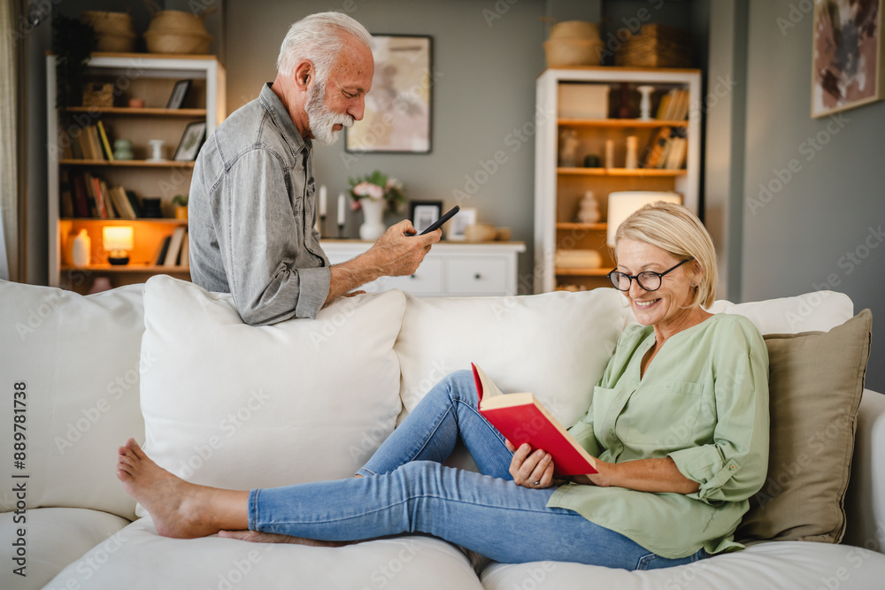 Mature wife lying down on sofa and read book whit her senior husband Mature wife lying down on sofa and read book whit her senior husband
