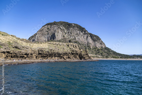 Spring view of tourists walking trail under volcanic rocks and cliff at Yongmeori Coast against Sanbangsan Mountain near Seogwipo-si, Jeju-do, South Korea
 photo