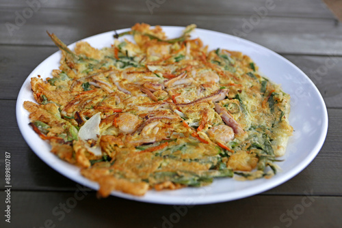 Close up of Haemul-pajeon(Seafood and Green Onion Pancake) on white dish and table of a restaurant near Sangju-si, South Korea 