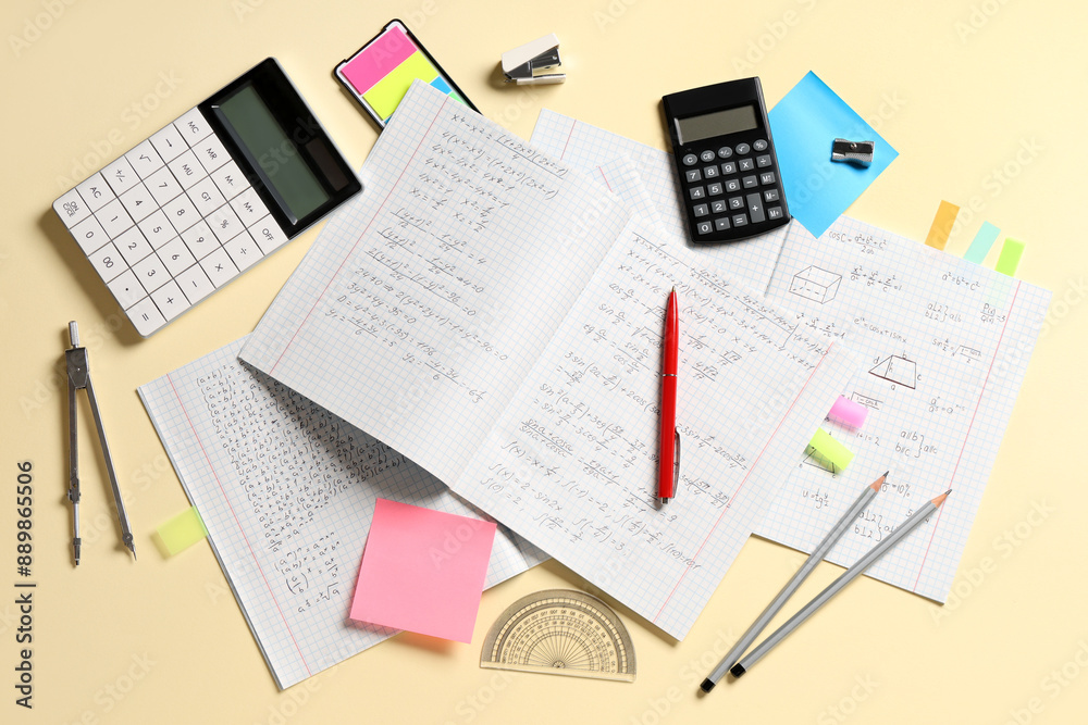Obraz premium Copybooks with handwritten maths formulas and stationery on yellow background