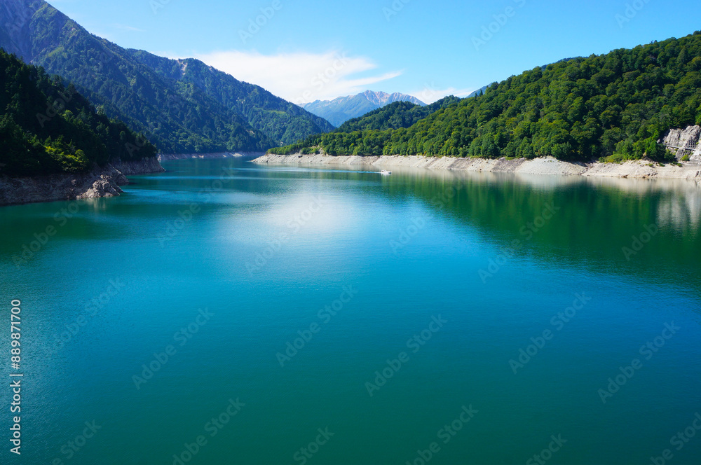 Obraz premium Beautiful Kurobe Dam Reservoir with Blue Sky and Mountains（日本の大きなダム「黒部ダム」の大きな貯水池のきれいな水面と青空と山）