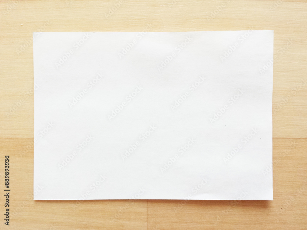 Fototapeta premium Blank Note Paper on Wooden Table（木目のテーブルに置いた白紙の小さなメモ用紙）