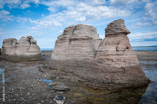 The weathered limestone monoliths of Île Nue de Mingan stand stoically against a dynamic sky, their sculpted forms testament to the relentless forces of nature at Mingan Archipelago National Park photo