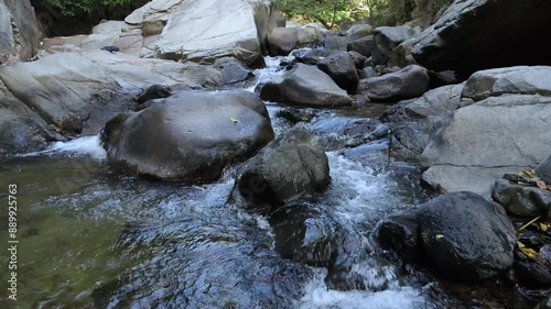 Aerial shot flying a River. river in the mountain, rocks and water, little waterfalls, huge rocks.