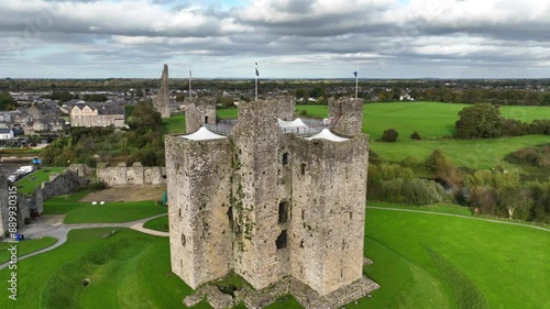 Trim Castle, County Meath, Ireland, October 2023. Drone close angle clockwise orbit of the Norman Fortress slowly ascending above the national monument, showing flags gently blowing in the wind. photo