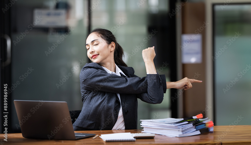 Relaxed office worker woman stretching hands and body taking break from work Relaxed office worker woman stretching hands and body taking break from work