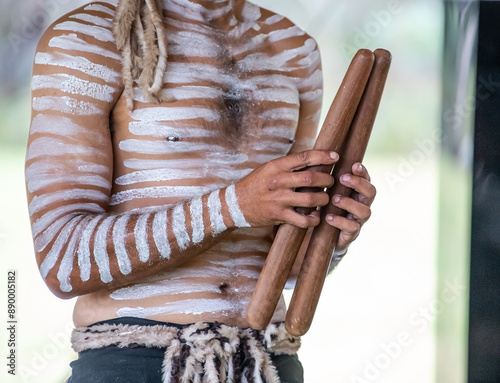 Australian aboriginal ceremony, human hand holds ritual clapsticks for the welcome rite at indigenous community event  photo