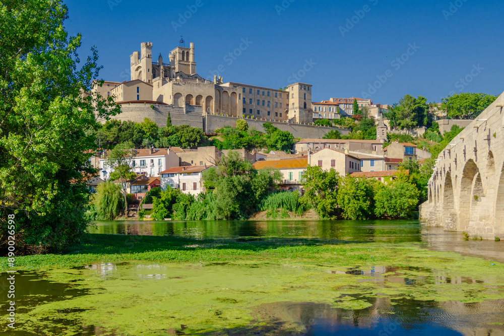 Cathedral Saint-Nazaire-A river runs through a town with a castle in the background Cathedral Saint-Nazaire-A river runs through a town with a castle in the background