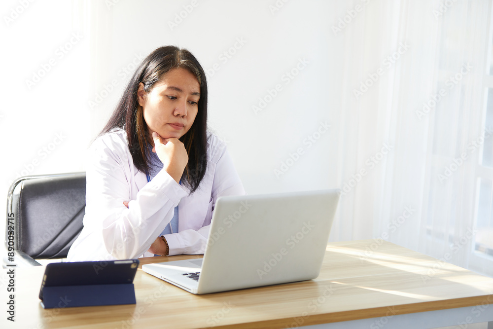 female doctor working on laptop computer and thinking about patients in the hospital female doctor working on laptop computer and thinking about patients in the hospital