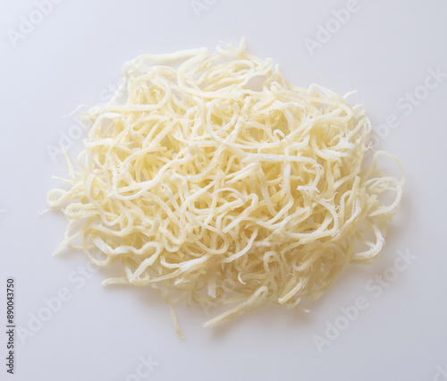 Close up and top angle view of stacked raw dried squid pieces on white floor, South Korea 