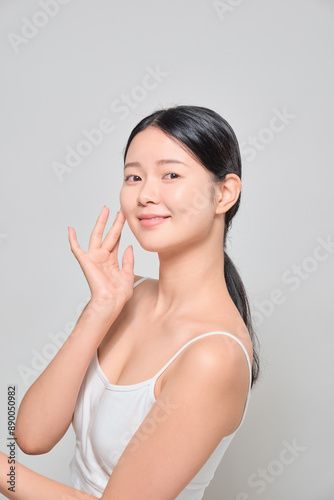 Female model smiling with confidence after applying makeup.