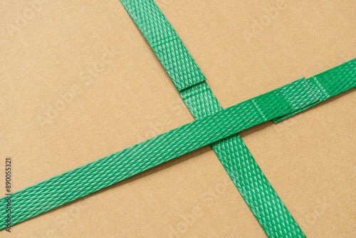 close up of green packaging plastic belt from the cardboard box that shows the connection point