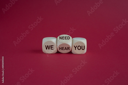 We need and hear you symbol. Turned a wooden cube and changes words we need you to we hear you. Beautiful red background. Business, support we need and hear you concept.