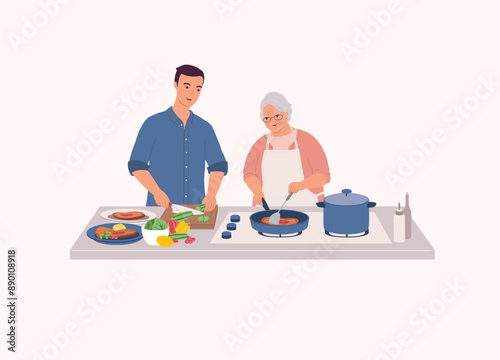 Smiling Older Mother In Apron Cooking Steak With Frying Pan. Adult Son Helping His Mum To Cut The Cucumber.