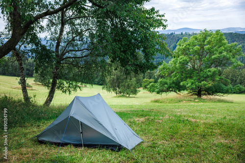 Fototapeta Naklejka Na Ścianę i Meble -  Camping at meadow in mountains. Ultralight tent for solo hiking. Adventure in nature