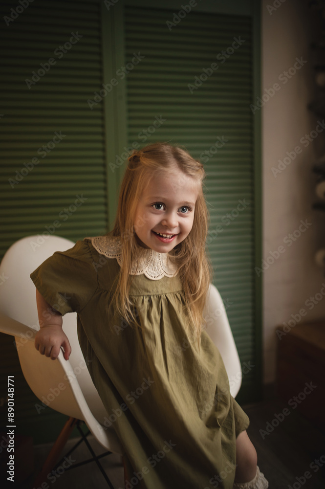 A 3-year-old girl in an elegant dress plays among the Christmas decorations. Film stylization, noise and scratches on the matrix, vintage toning, blurry image