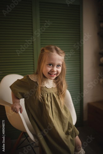 A 3-year-old girl in an elegant dress plays among the Christmas decorations. Film stylization, noise and scratches on the matrix, vintage toning, blurry image