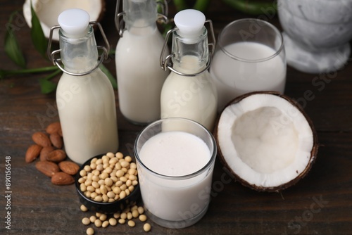 Different types of vegan milk and ingredients on wooden table
