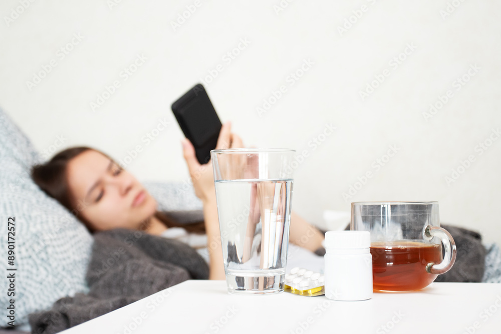 Online pharmacy, young sick woman orders medicines on a smartphone, virus treatment with prescribed medicine, ordering pills online, patient health care management. Online pharmacy, young sick woman orders medicines on a smartphone, virus treatment with prescribed medicine, ordering pills online, patient health care management.