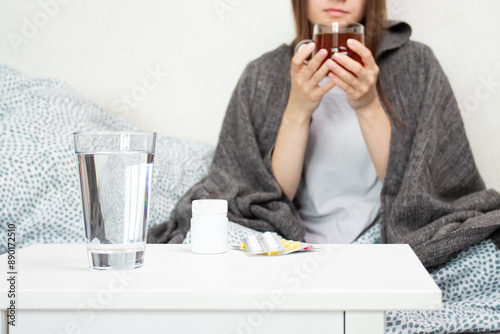 Tableau sur toile Sick teen drinks hot tea, teenager managing a cold, ill person experiencing an infection