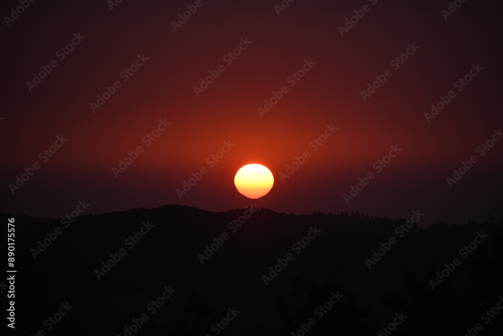 Epic sunset landscape sky with big bright sun going behind the mountains in Corfu,Greece,Europe Epic sunset landscape sky with big bright sun going behind the mountains in Corfu,Greece,Europe