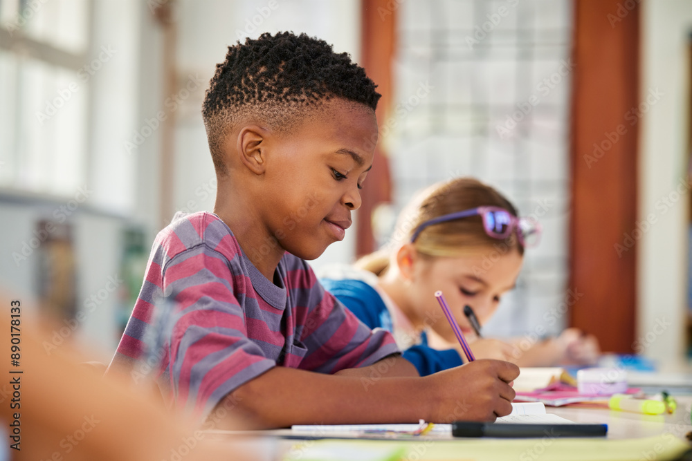 © Rido - Little african boy writing in classroom during test