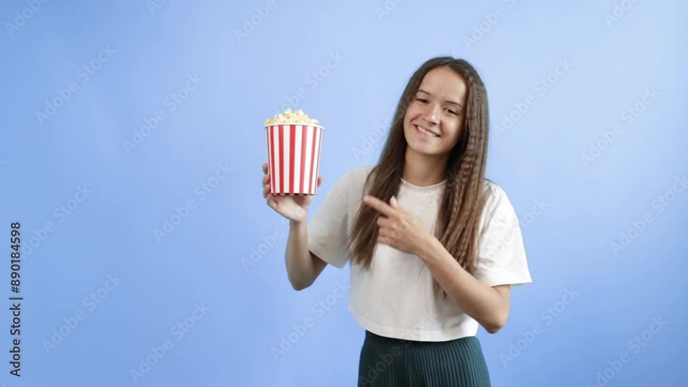 Popcorn in cinema, teenage girl with movie pop corn, curly student enjoying crunchy treat. Popcorn in cinema, teenage girl with movie pop corn, curly student enjoying crunchy treat.